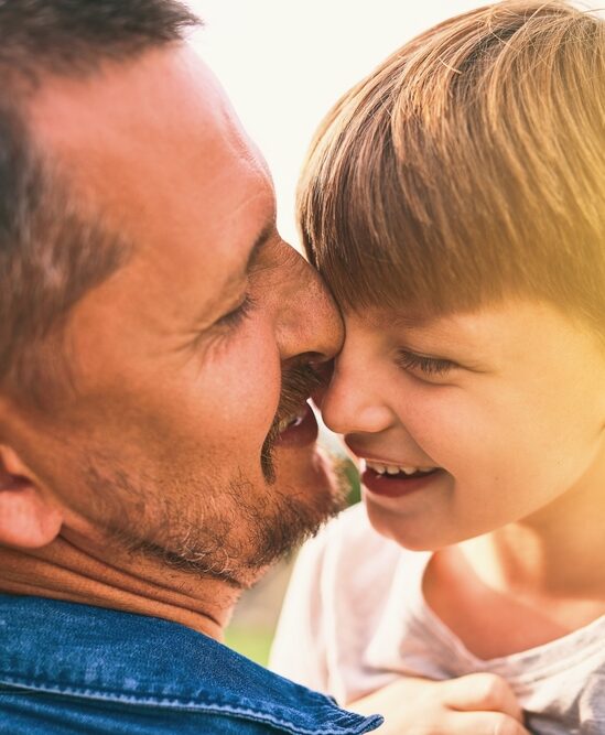 un pere et son fils enlacé