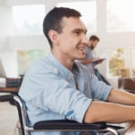 homme en fauteuil roulant devant un ordinateur