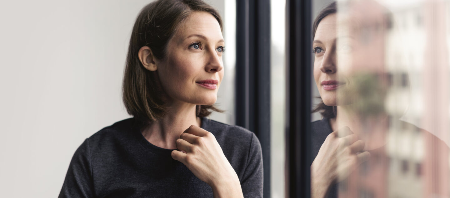 femme pensive devant une fenetre