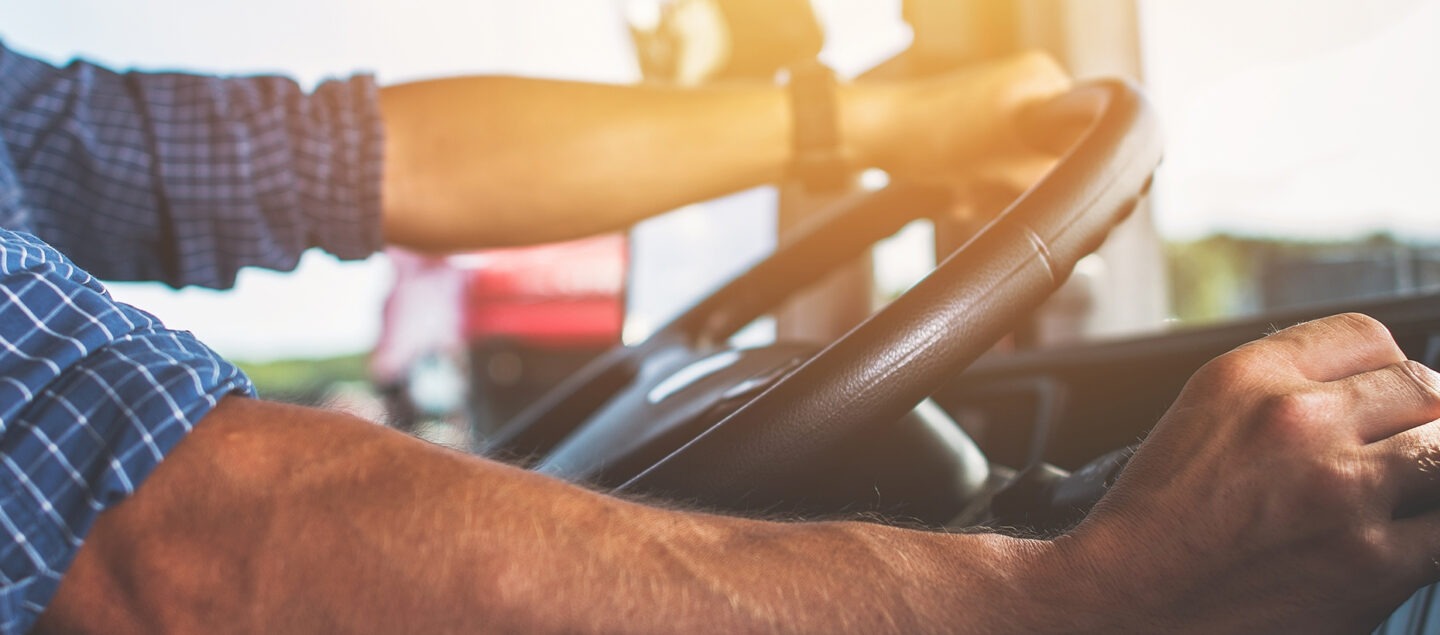 main d'homme sur un volant et un levier de vitesse