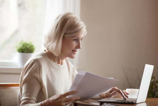 femme regadant ordinateur avec documents