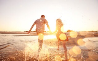 couple heureux courant face a la mer
