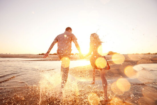 couple heureux courant face a la mer