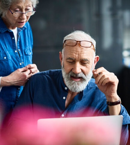 homme à la barbe devant un ordinateur et femme regardant