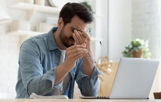 homme fatigué devant son ordinateur