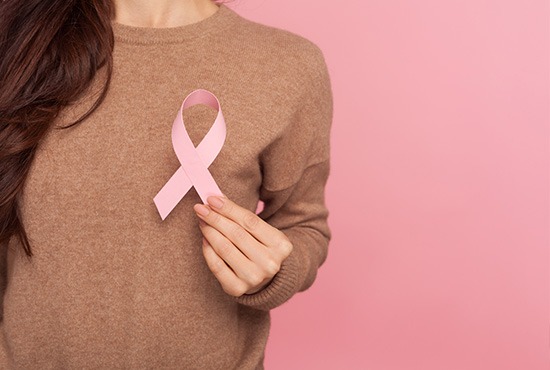 femme tenant un noeud rose pour le cancer du sein