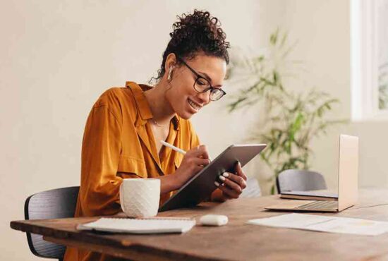 femme qui regarde une tablette à son bureau