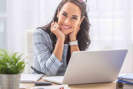 femme devant son ordinateur souriante