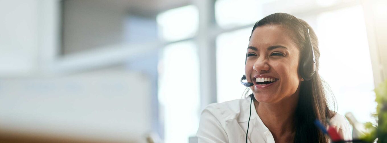 femme souriante au téléphone dans un centre d'appel