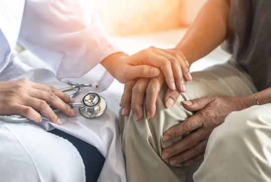 Un médecin tenant la main d'un patient atteint du Parkinson