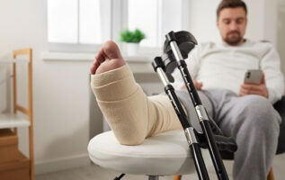 personne avec un platre à la jambe qui fait une demande sur son telephone