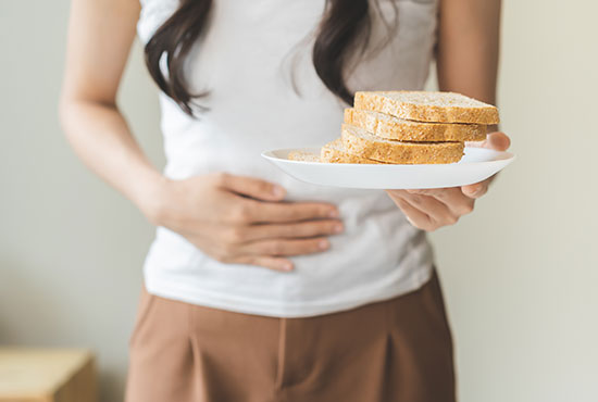 Femme tenant une assiette de pain - Gluten