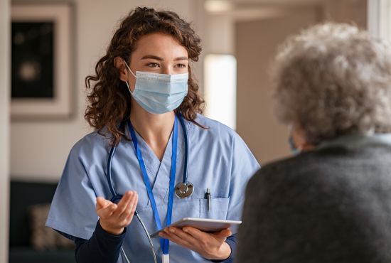 Infirmière aidant une mamie qui a le Covid19.