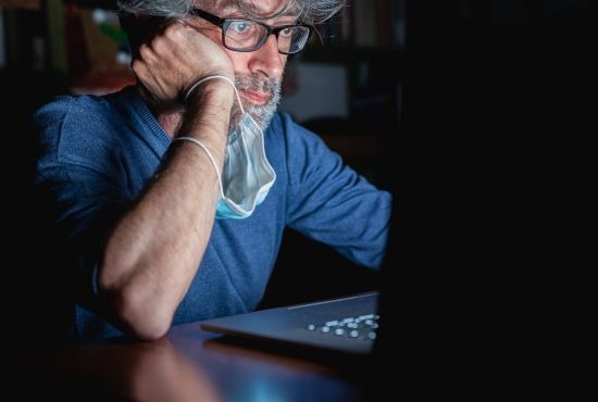 Homme atteint d'hypocondrie devant son ordinateur.