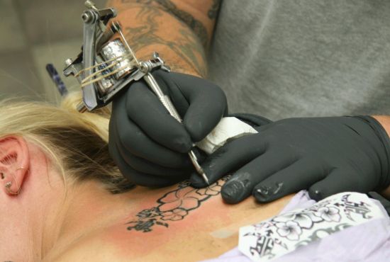 Femme en train de se faire un tatouage.