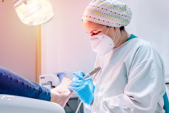 Podo-orthésiste qui pratique des soins sur un patient.