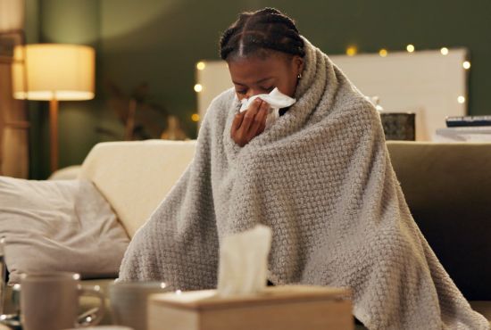 une femme en manque de vitamine d en train de se moucher