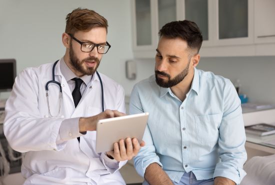 Médecin présentant un devis médical à un patient lors d’une consultation, illustrant la compréhension des frais de santé.