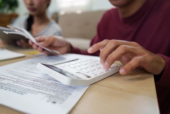 une personne tenant sa calculatrice à la main entrain d'anticiper ses dépenses santé