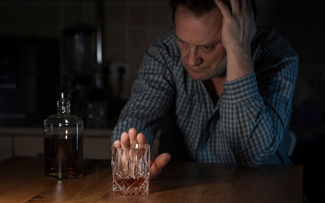 homme qui repousse un verre d'alcool
