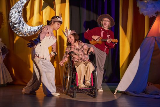 Trois jeunes comédiens sur scène, dont un en fauteuil roulant, célébrant la Journée mondiale du théâtre.
