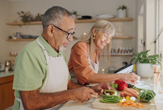 un couple de sénior en train de faire à manger