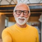 homme senior à lunette noire qui sourit