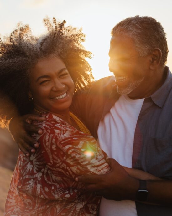 couple senior devant un couché de soleil